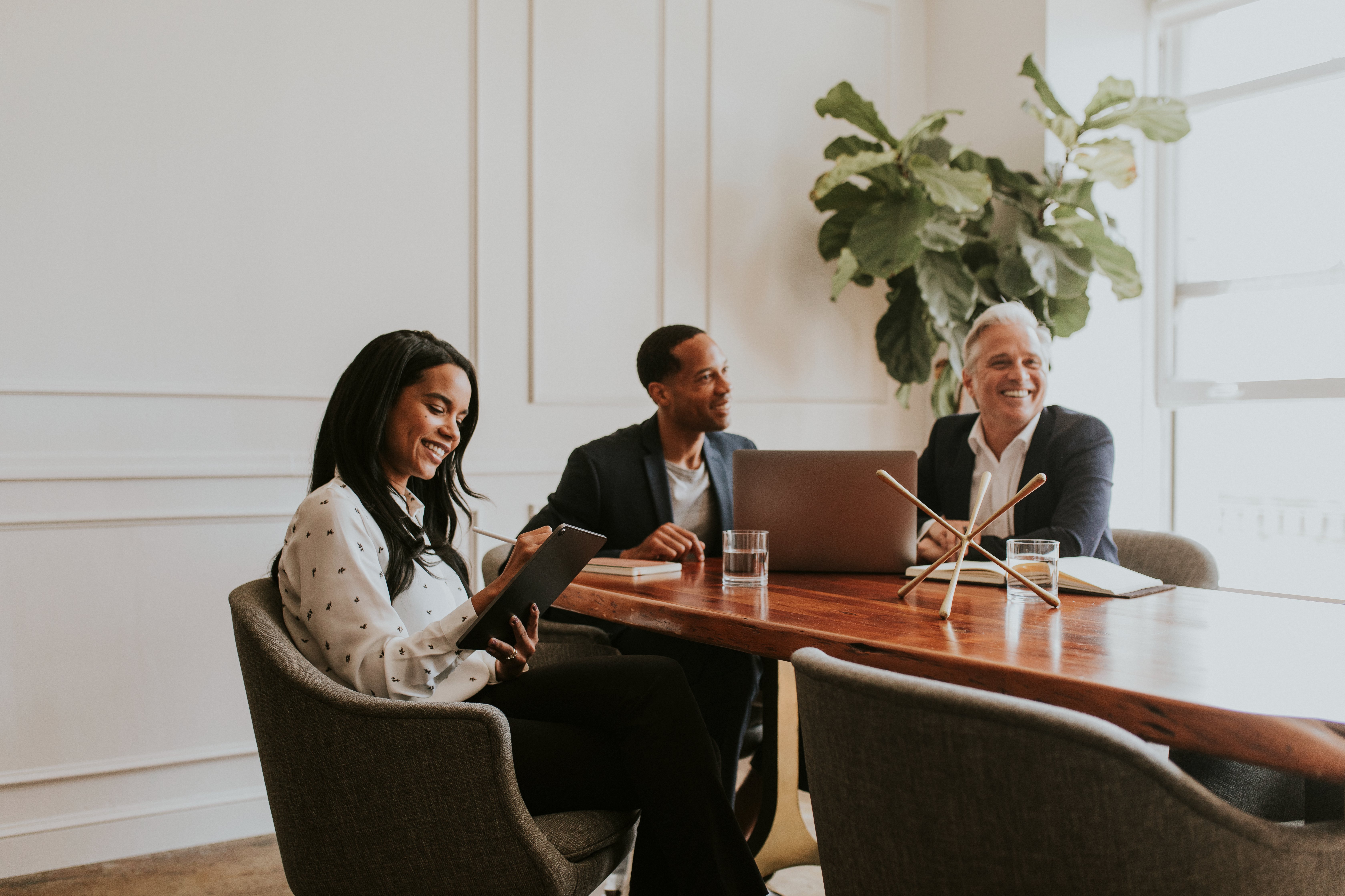 Three happy business professionals discussing lead generation strategies at a meeting